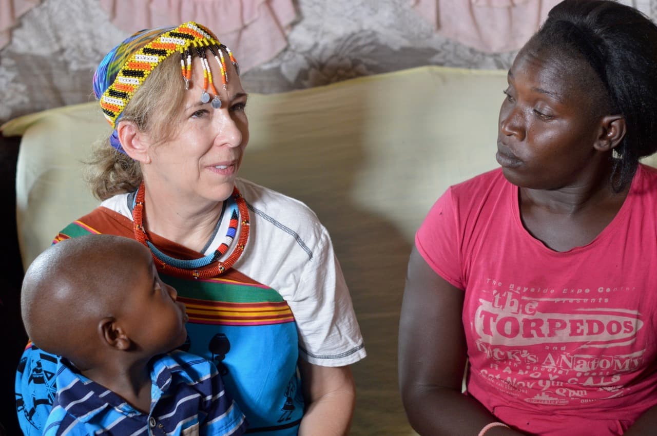 An earlier photograph: Eldonna holding a child beside a woman in a pink shirt